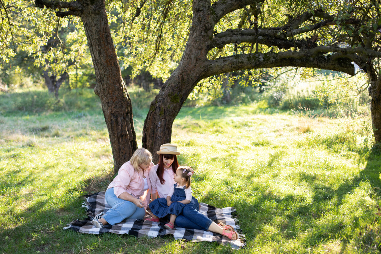Familie sitzt unter Baum
